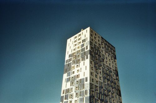 Free Low angle view of a modern high-rise building with unique window patterns against a clear sky. Stock Photo