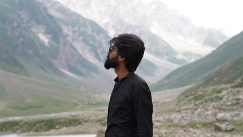 Free Man in sunglasses enjoys stunning view of Khyber Pakhtunkhwa mountains. Stock Photo