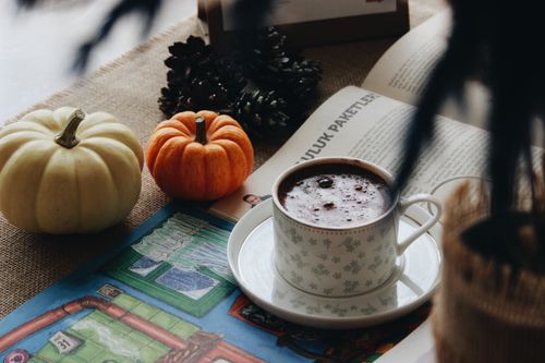 Free Warm autumn setup with a cup of coffee, pumpkins, and a magazine for a cozy vibe. Stock Photo
