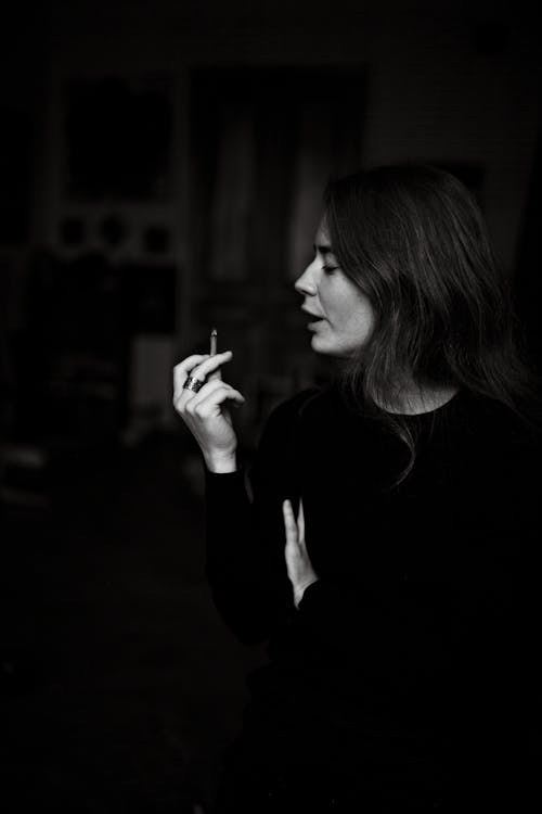 Free Woman in Black Long Sleeve Shirt Smoking Stock Photo