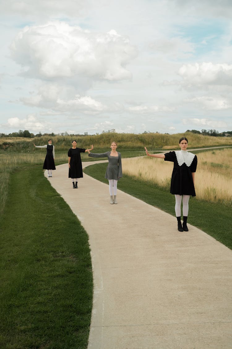 Four Women Standing On Concrete Pathway