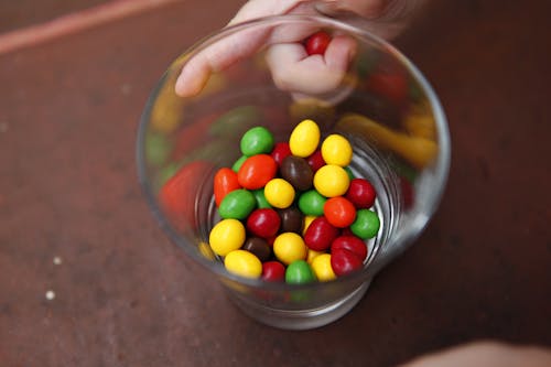 Close-Up Photo of a Glass with Colorful Candies