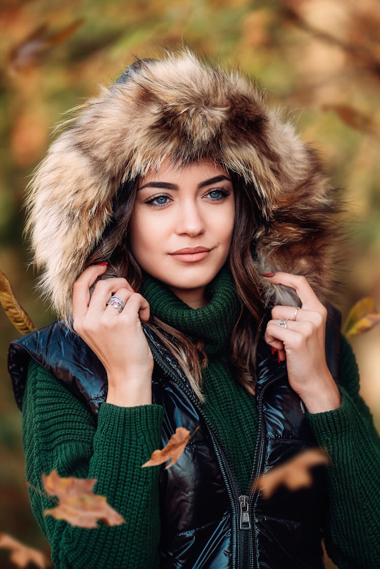 Woman In Green Turtleneck And Fur Hoodie Vest