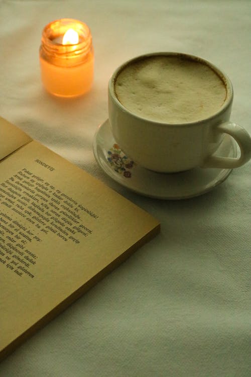 Free Cup of Coffee Beside a Lighted Candle Stock Photo