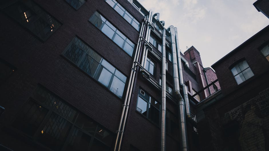 Nowoczesna łazienka z widocznymi rurami wodnymi i baterią, kontekst uderzeń hydraulicznych