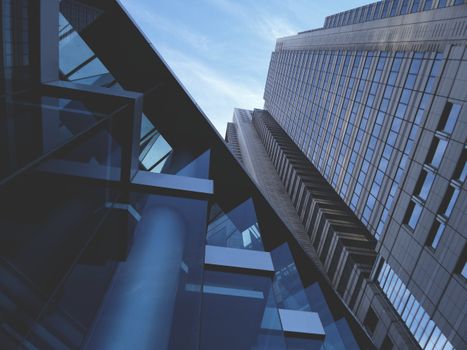 A dynamic low angle view of modern glass skyscrapers under a blue sky.