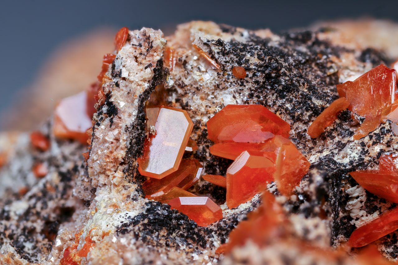 detailed close up of orange wulfenite crystals on mineral surface