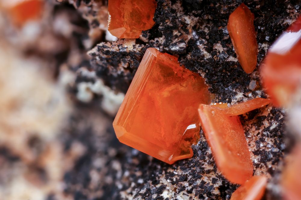 Macro of red crystals on a dark mineral base