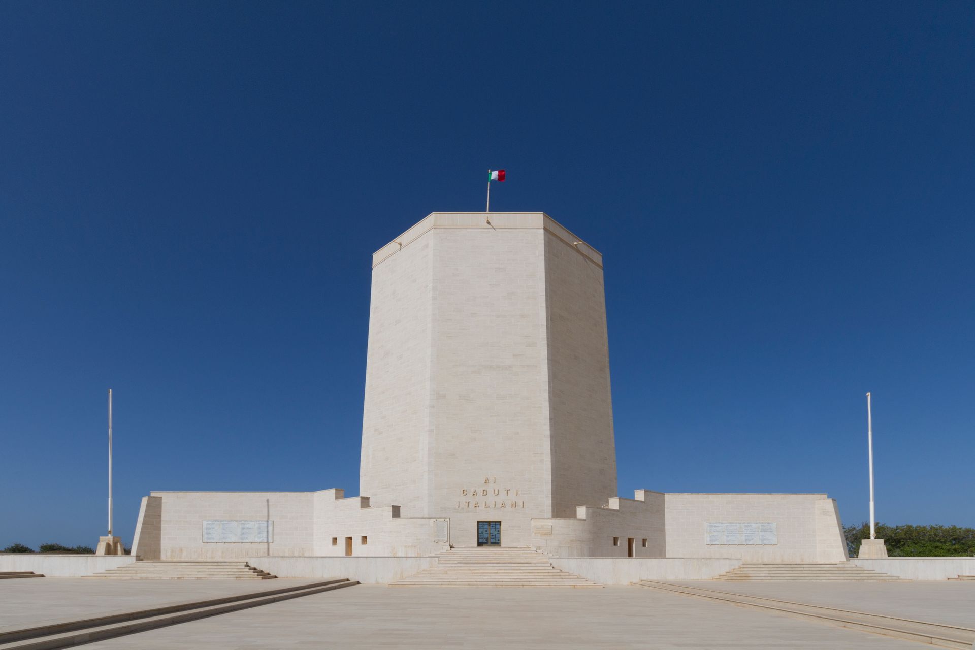 A majestic memorial tower in Italy with clear blue skies, symbolizing peace and remembrance.