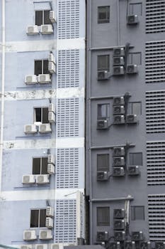 Close-up of building facade in Kuala Lumpur with multiple air conditioning units visible.