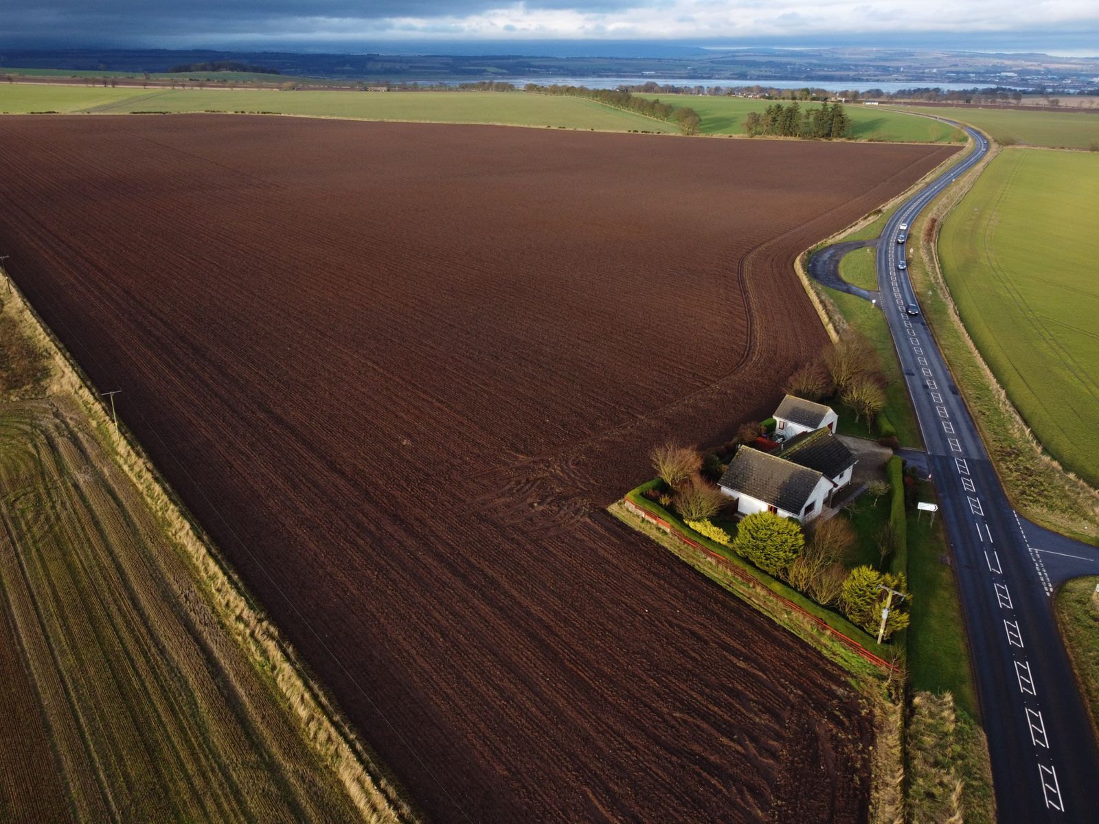 Aerial view of farmland with a cottage in rural Scotland