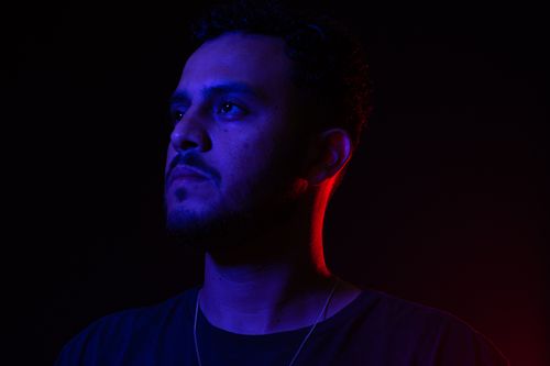 Free A moody portrait of a man with colored lighting effects creating a dramatic atmosphere. Stock Photo