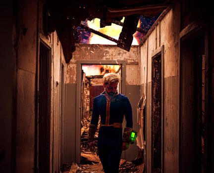 A person in cosplay suit explores a damaged corridor with a green glowing device amidst rubble.
