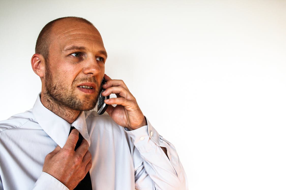 Man Wearing White Dress Shirt Holding Smartphone