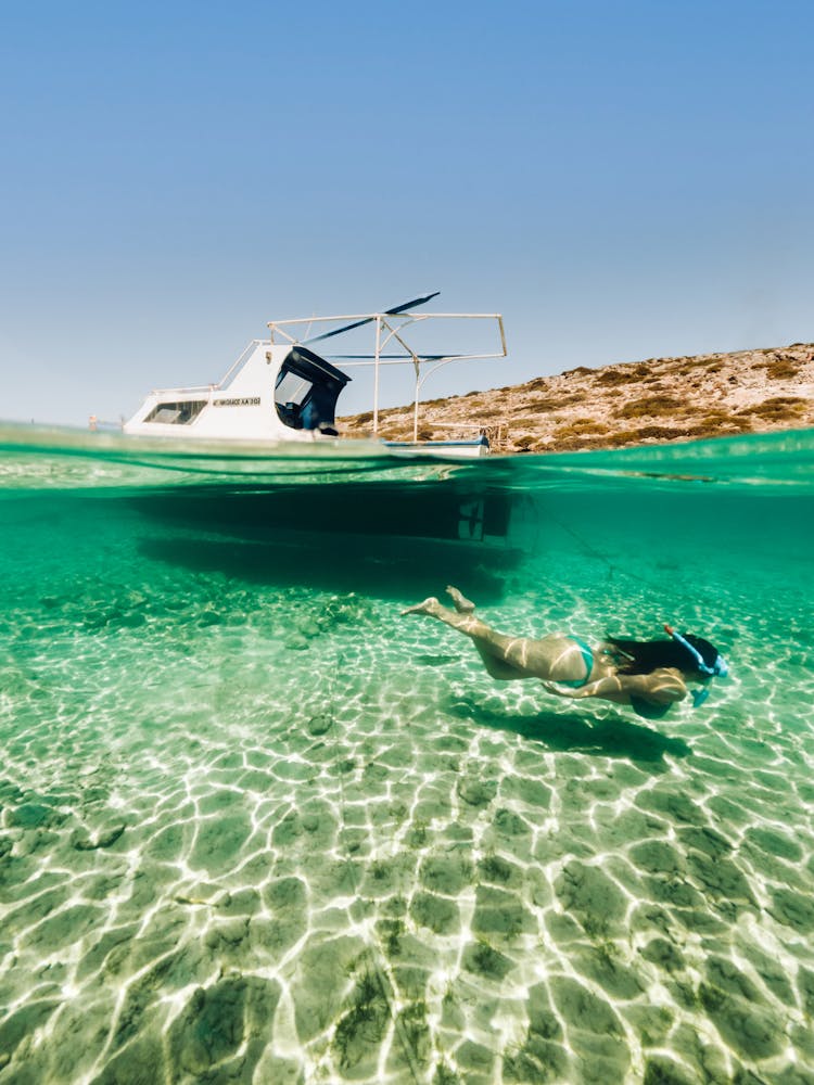 Woman Snorkelling Next To A Small Boat 