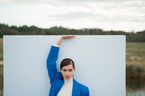 Woman in a Blue Blazer Posing with Her Hand Up