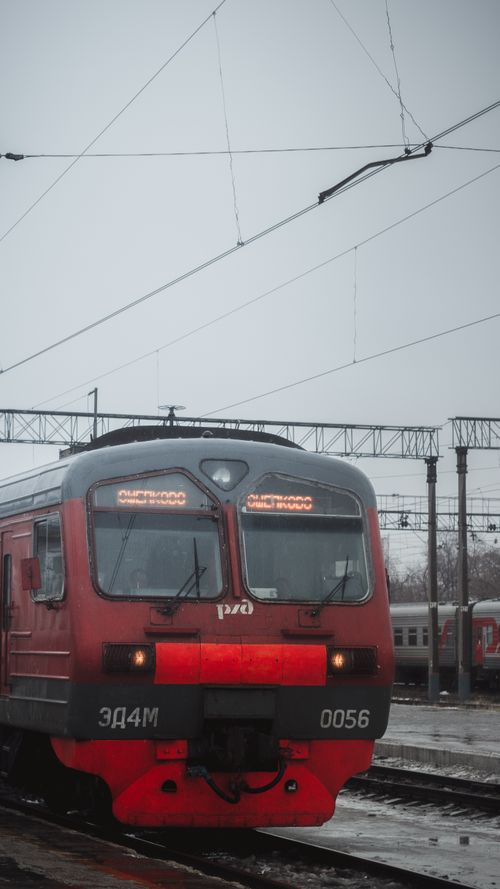 Free A red train approaches a foggy railway station, showcasing transportation in a misty atmosphere. Stock Photo