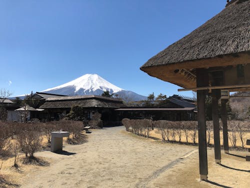 Brown Wooden Huts Near Mountain Under Blue Sky