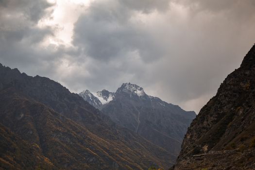 A breathtaking view of mountains under thick clouds, showcasing nature's dramatic beauty.