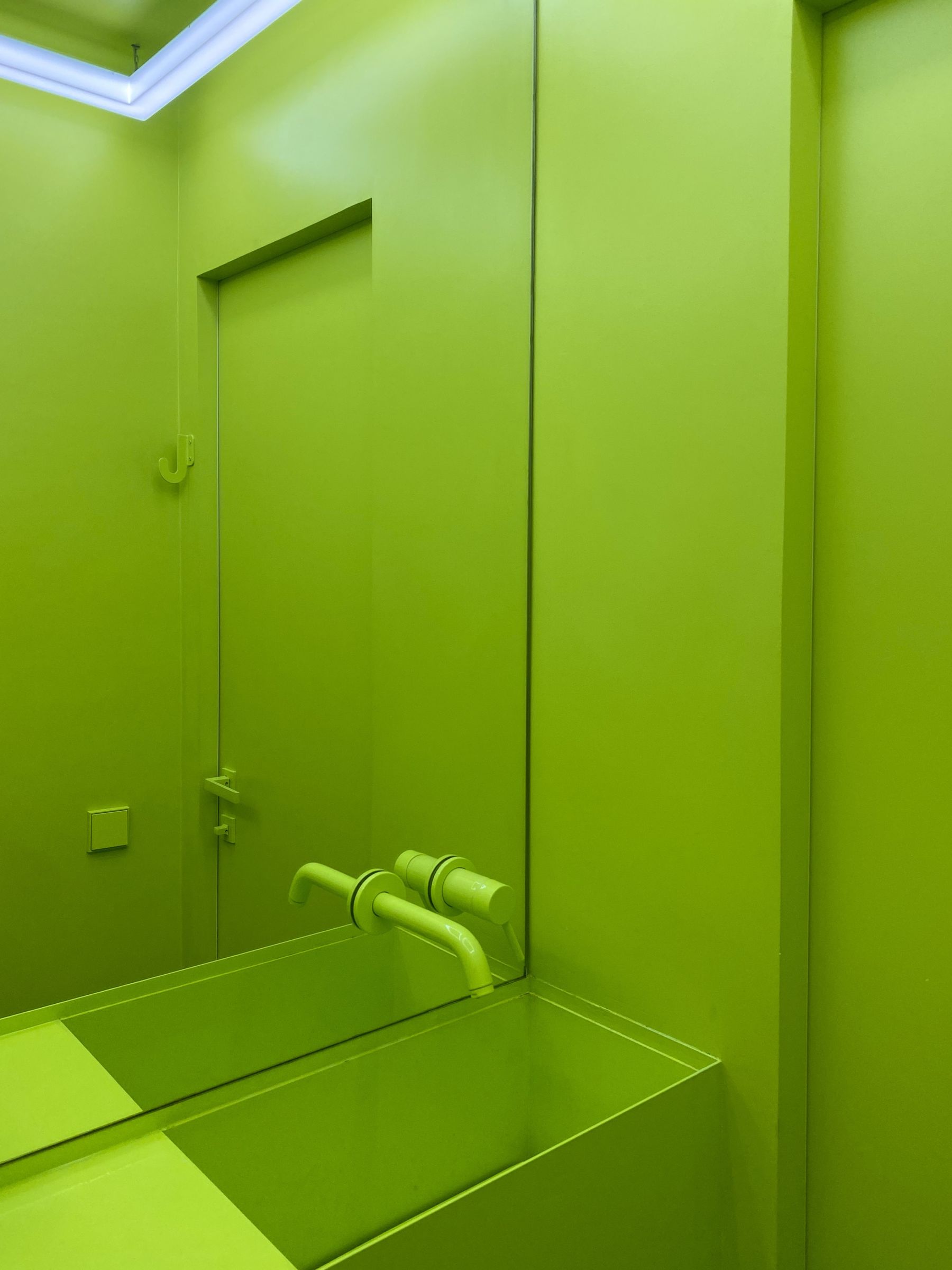 Bright green bathroom with sleek sink and mirror