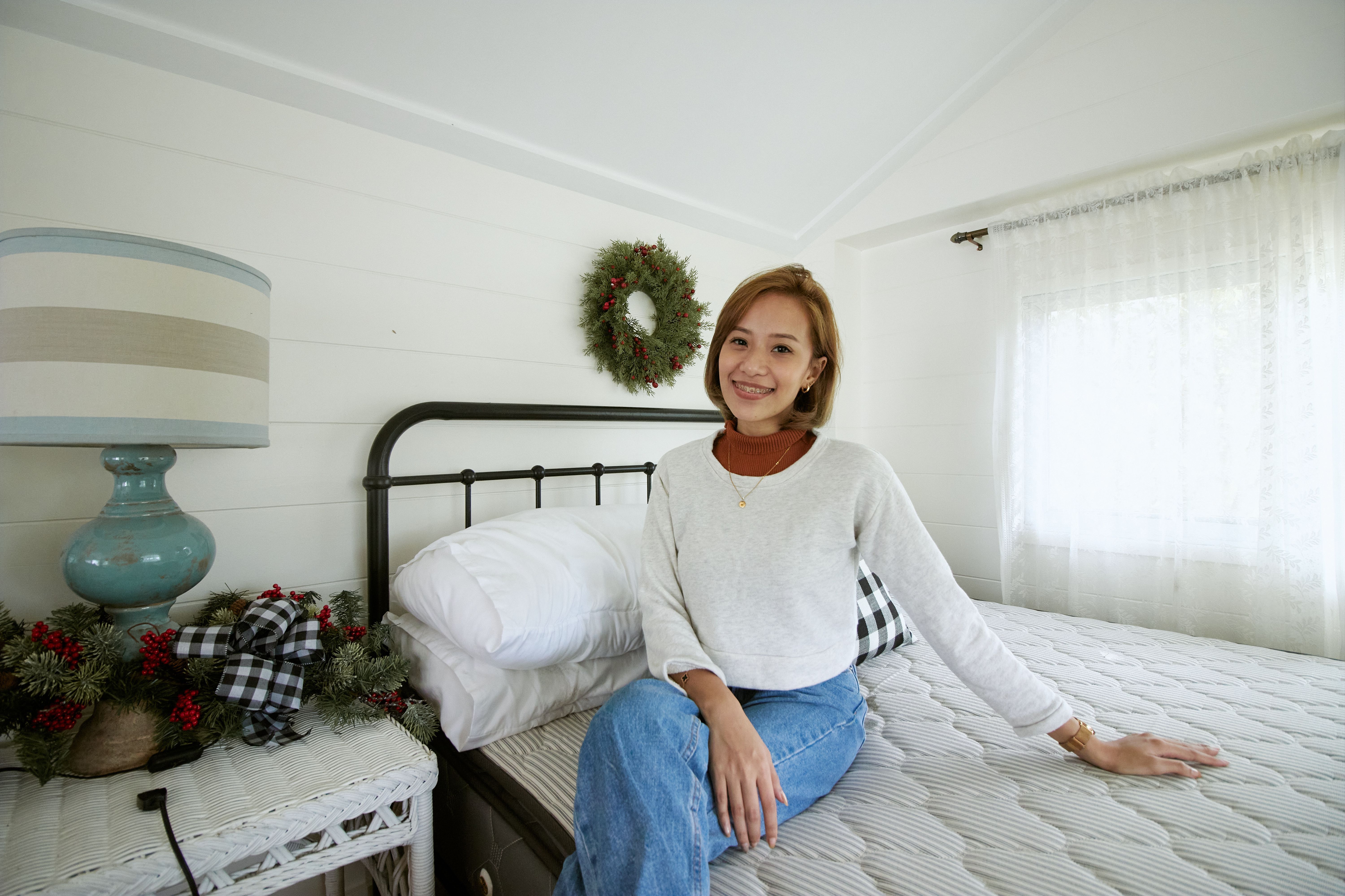 Woman in White Sweater sitting on a Bed · Free Stock Photo