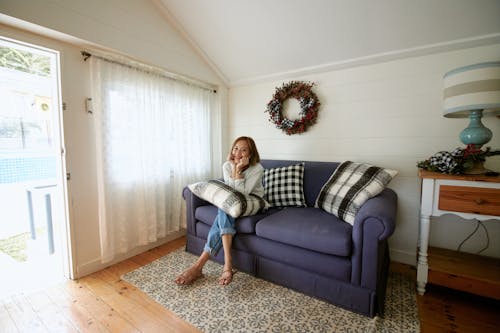 Photo of a Woman Sitting on a Purple Sofa