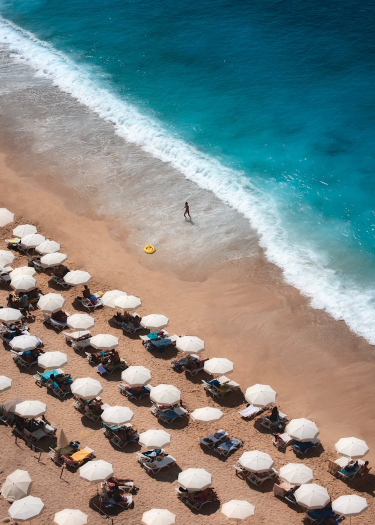 Drone Shot Of A Beach With White Umbrellas