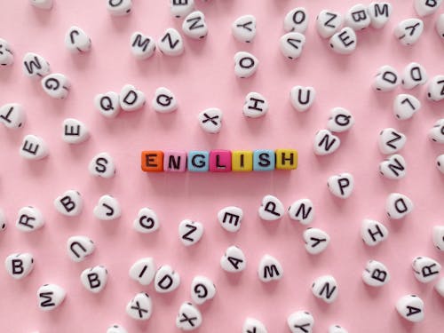 The Word "English" Made of Beads with Letters Lying on Pink Background 