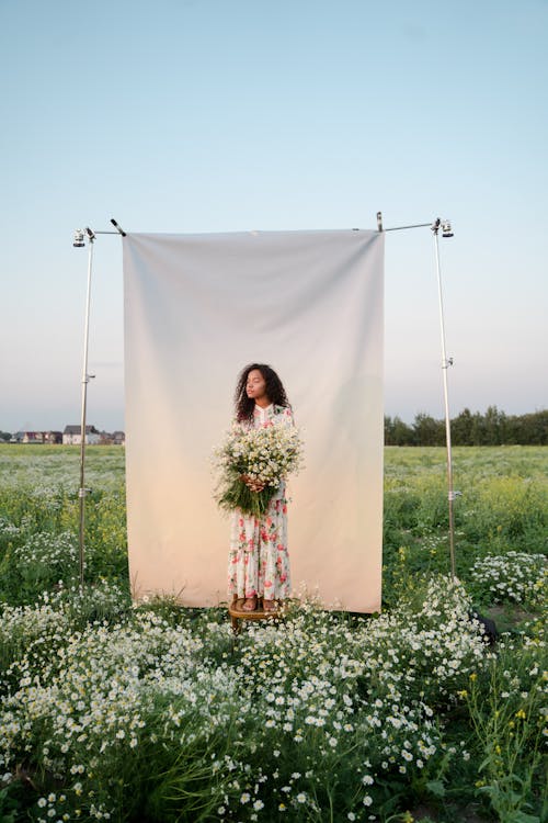 Young Woman Standing on Stool on Flower Field