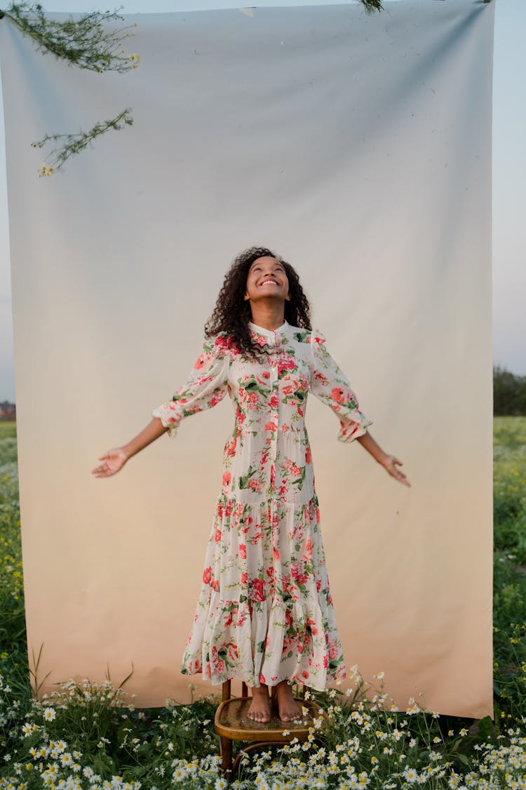 Woman Standing On Chair On Flower Field 