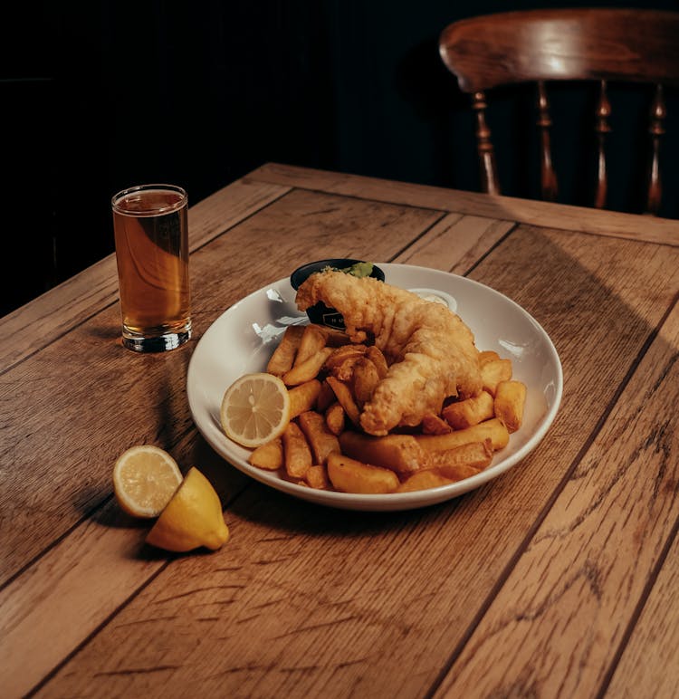 Fish, Potato Chips And Lemon Slice On Plate