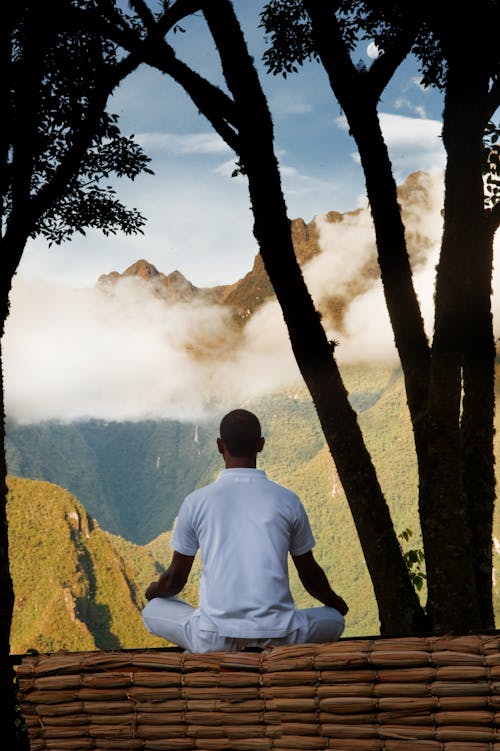 Back View of a Man in a White Shirt Meditating