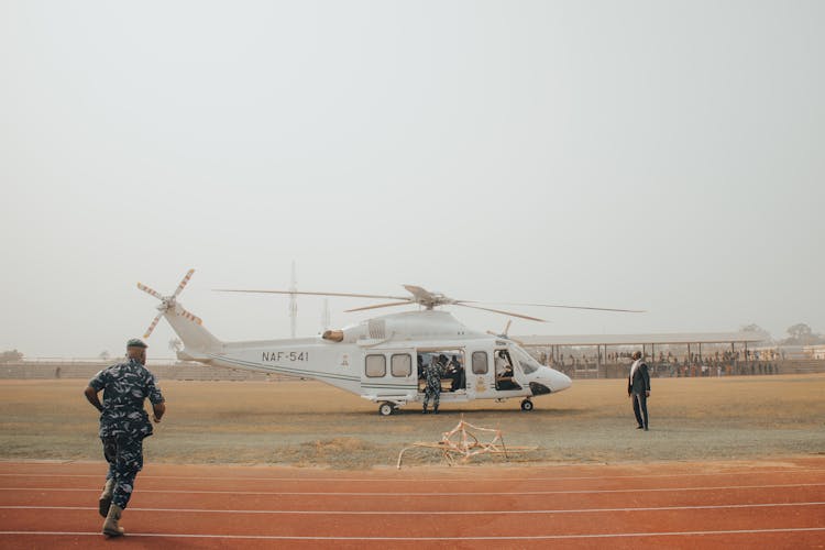 Soldier Running To Helicopter On Sport Pitch