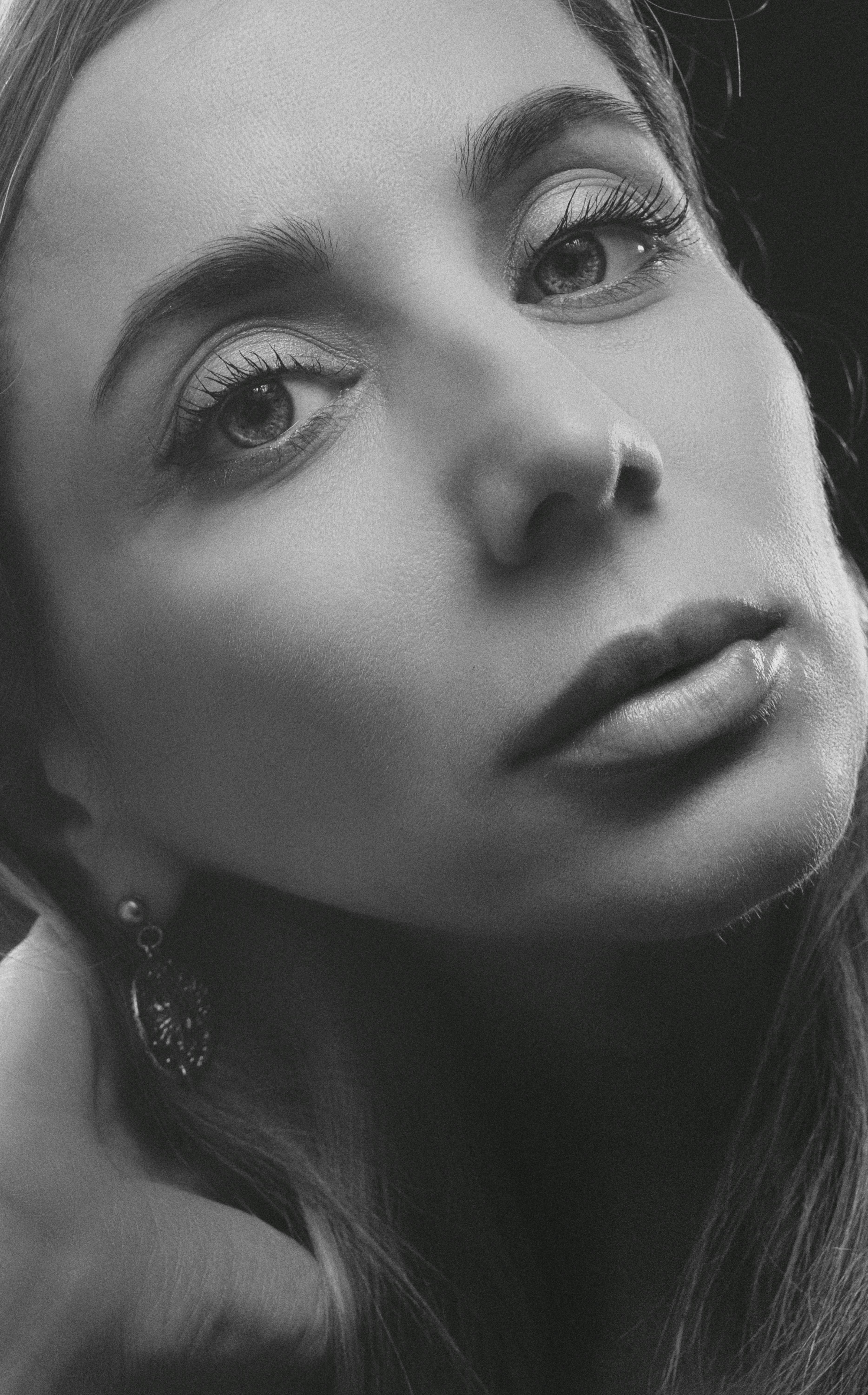 Captivating black and white close-up portrait of a woman exuding elegance.