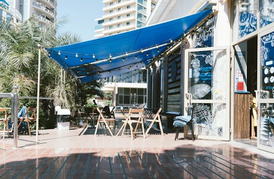 索契迷人的户外咖啡馆设有蓝色天篷，其现代化的露台座椅沐浴在日光下