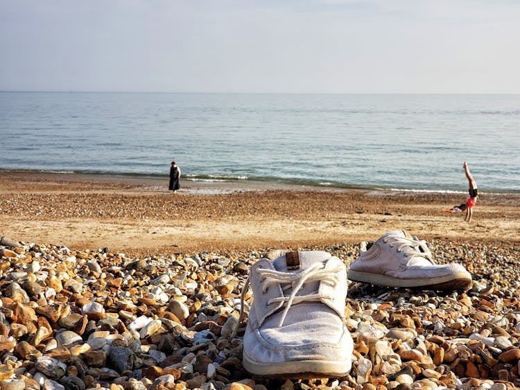 Shoes Lying On Rocks On Beach