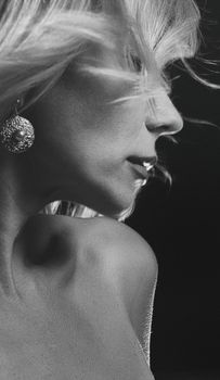 Elegant black-and-white side profile of a woman with flowing hair and jewelry.