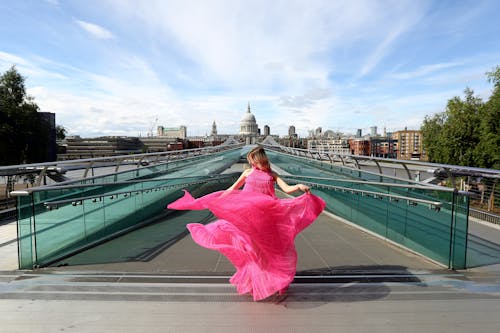 Model Posing in a Pink Dress in Front of the Millennium Bridge