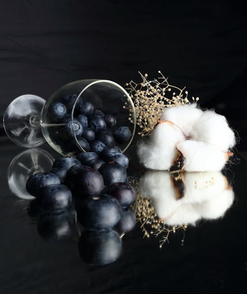 Blueberries Spilling out of Glass Lying Next to Piece Cotton 