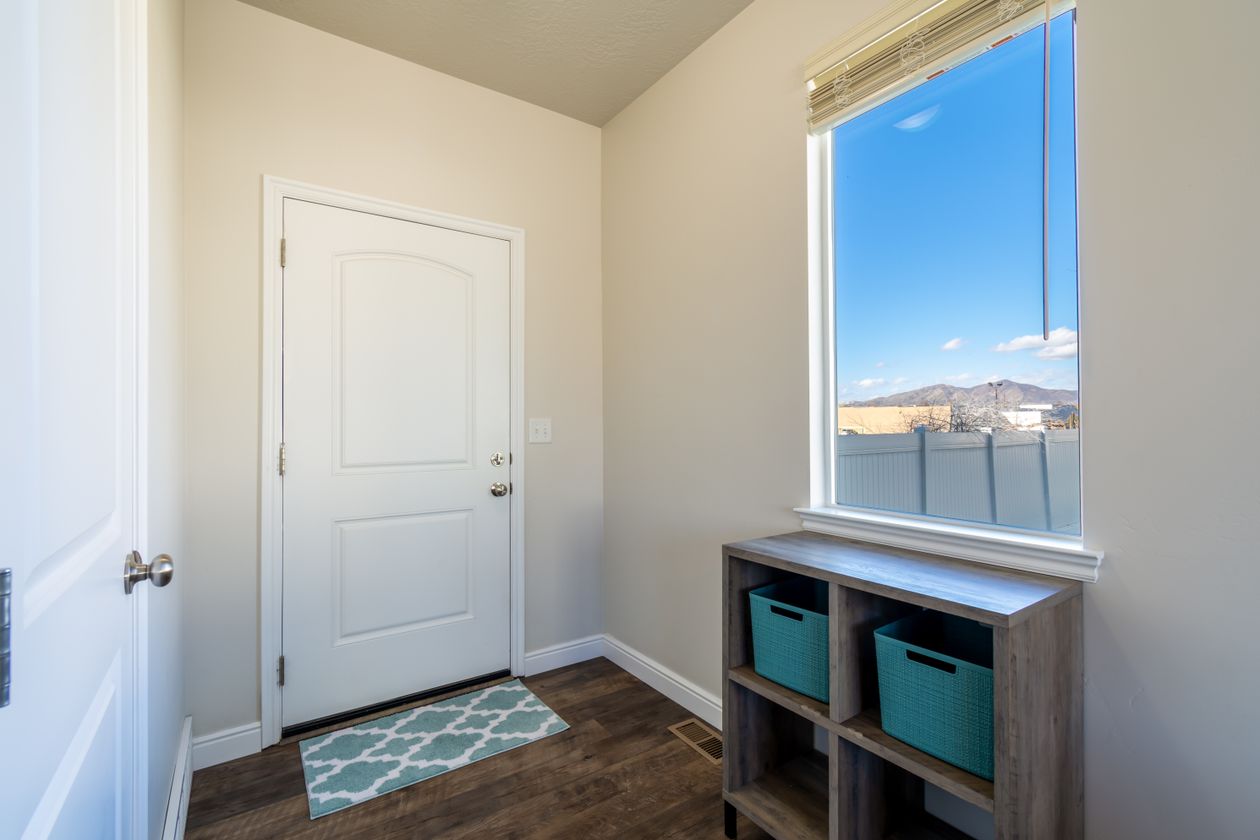 Small entryway with a gray cube storage unit holding teal fabric bins