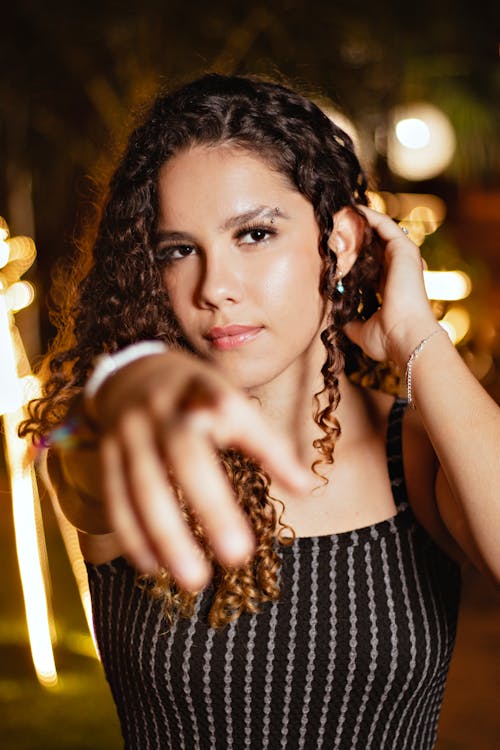 Selective Focus of a Curly-Haired Woman Pointing Her Finger