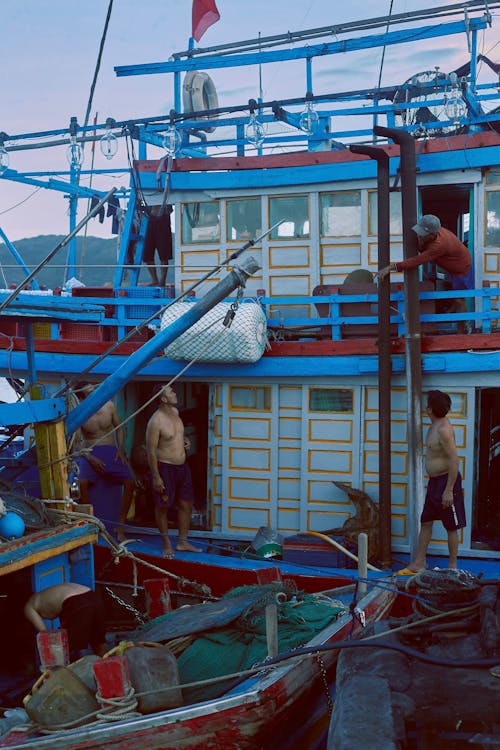 Group of Men on Red and Blue Fishing Boat