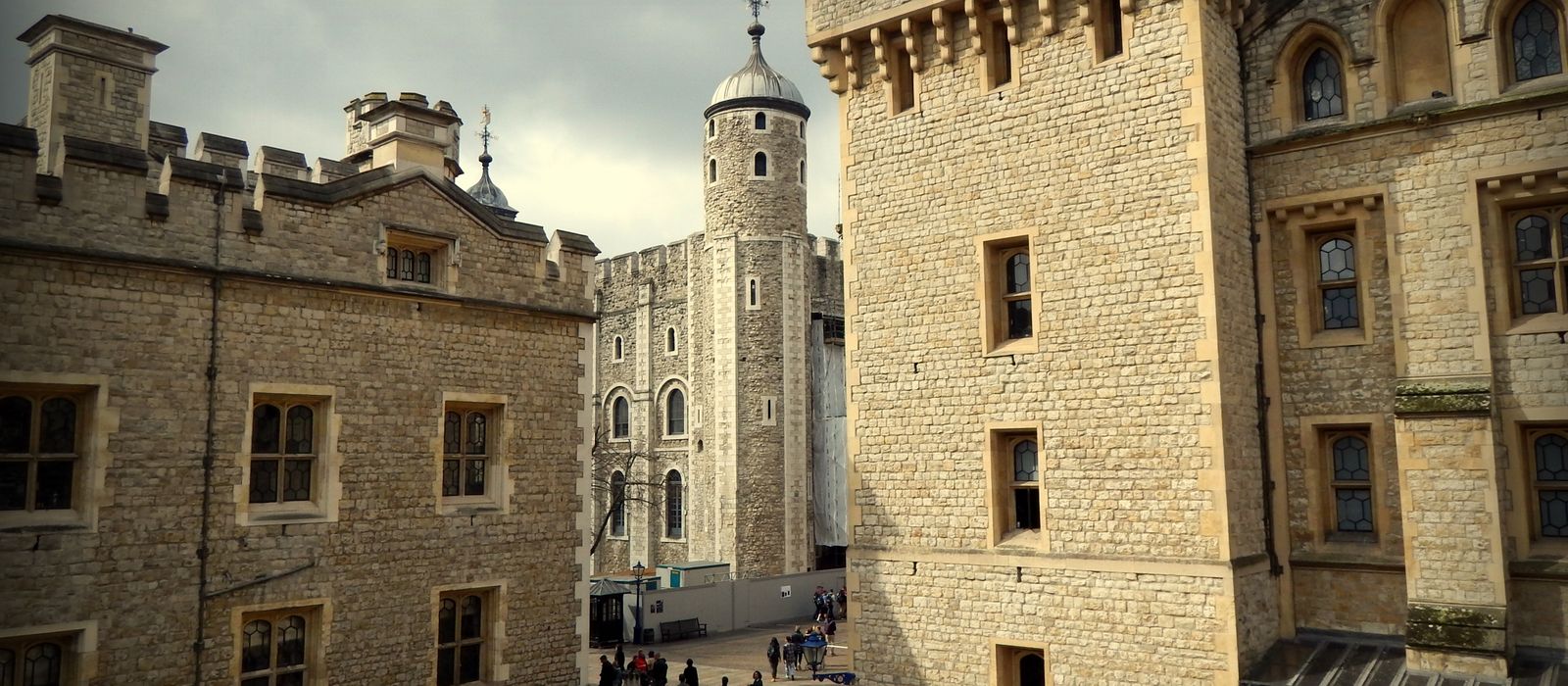 View of the historic Tower of London with stone walls and turrets, popular tourist destination.