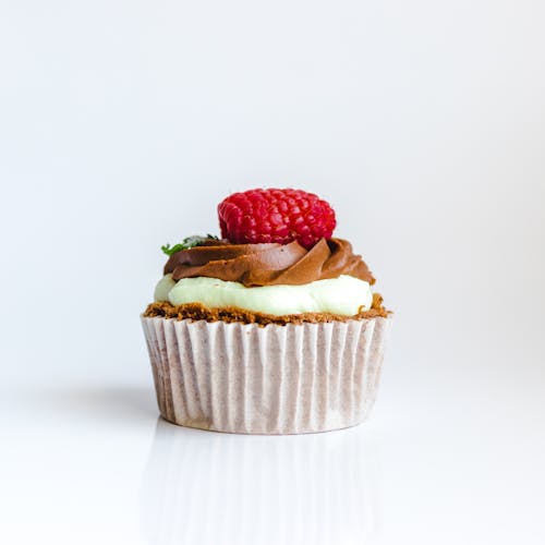 Fotografia Di Cupcake Al Cioccolato Con Guarnizioni Di Fragole Rosse