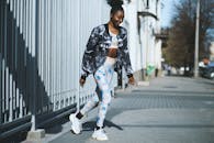 一位身着运动服的时尚女性，走在阳光明媚的城市人行道上，拥抱健身与时尚