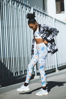 一位穿着健身装备的时尚女性自信地在城市街道上摆姿势