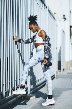 一位年轻的黑人女性穿着现代健身服在户外锻炼，展现了城市运动时尚