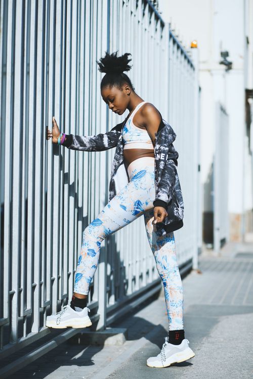 Free Young black woman exercising outdoors, dressed in modern fitness wear, showcasing urban workout fashion. Stock Photo