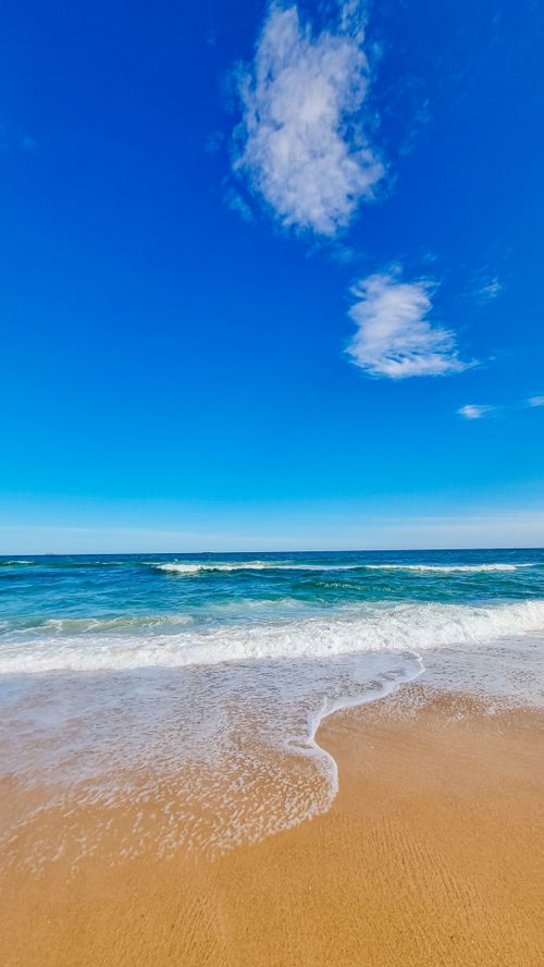 Beach Waves Crashing on Sand Under the Blue Sky · Free Stock Photo
