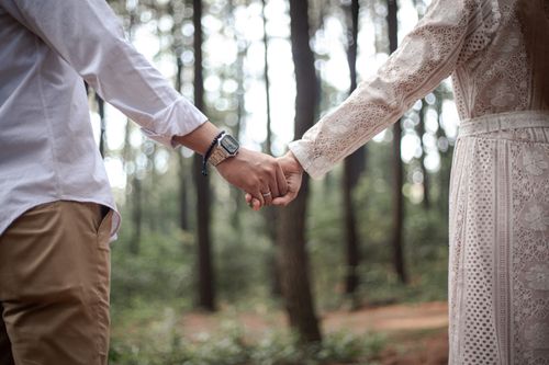 Free A couple holding hands in a peaceful forest, symbolizing love and togetherness. Stock Photo
